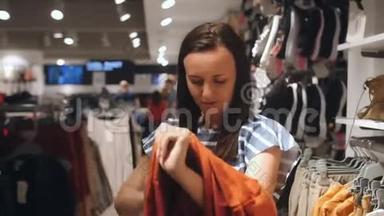 在服装店试穿衣服的女人。 女人在商店里挑选衣服。